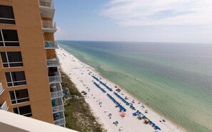 A high-rise hotel with balconies overlooking a beach with rows of umbrellas and sun loungers. - Celestial Sands 1901A–Stunning Views–Sleeps 8 (Panama City Beach)