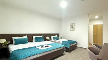 Habitación triple, vistas a la piscina | Caja fuerte, escritorio, cortinas opacas y sistema de insonorización