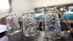 Tre contenitori di vetro con la scritta 'DISINFECTED', posati su un tavolo.