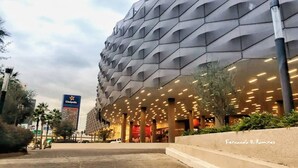 Ein modernes Gebäude mit einer einzigartigen, geometrischen Fassade und einem gut beleuchteten Eingangsbereich.