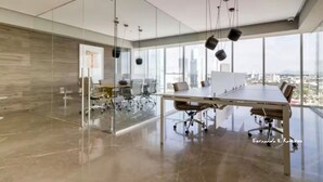 Ein moderner Konferenzraum mit Glastrennwand, einem langen Tisch mit Stühlen und Blick auf die Stadt.