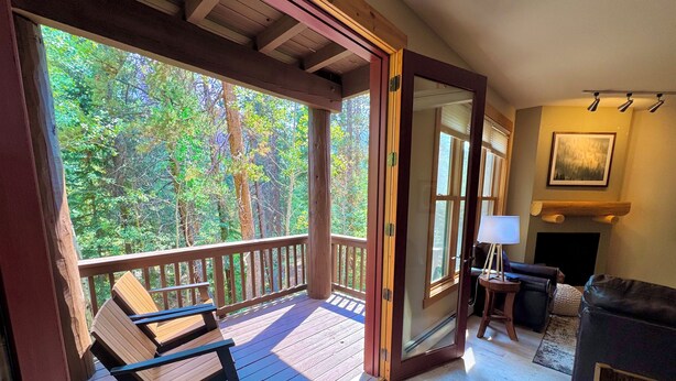 A wooden deck with a bench, a fireplace, and a sofa. - Dog friendly, hot tub, free shuttle (Keystone)