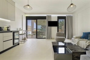 A modern living room with a sofa, a coffee table, and a TV mounted on the wall. - Apartment 'Mella Roa - Ivory' with Sea View, Wi-Fi and Air Conditioning (?e???????)