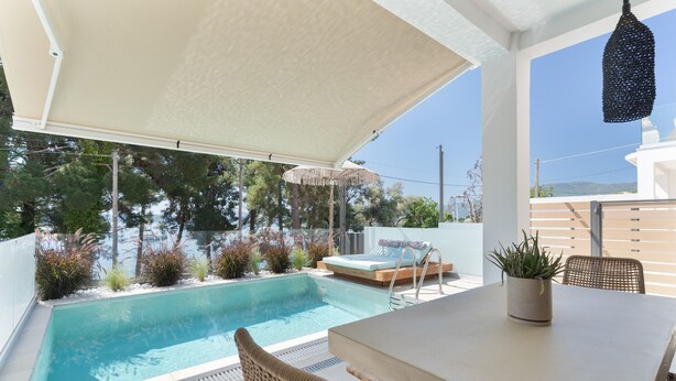 A poolside area with a table, chairs, a covered seating area, and a hanging light fixture. - Villa 'Mella Roa -  Onyx' with Sea View, Wi-Fi and Air Conditioning (?e???????)
