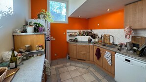 Una cocina con armarios de madera, lavavajillas y una ventana.