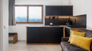 A modern kitchen with dark cabinetry, a built-in oven, and a coffee maker. - Apartment 'Schmetterling' with Mountain View, Shared Terrace and Wi-Fi (Seis)
