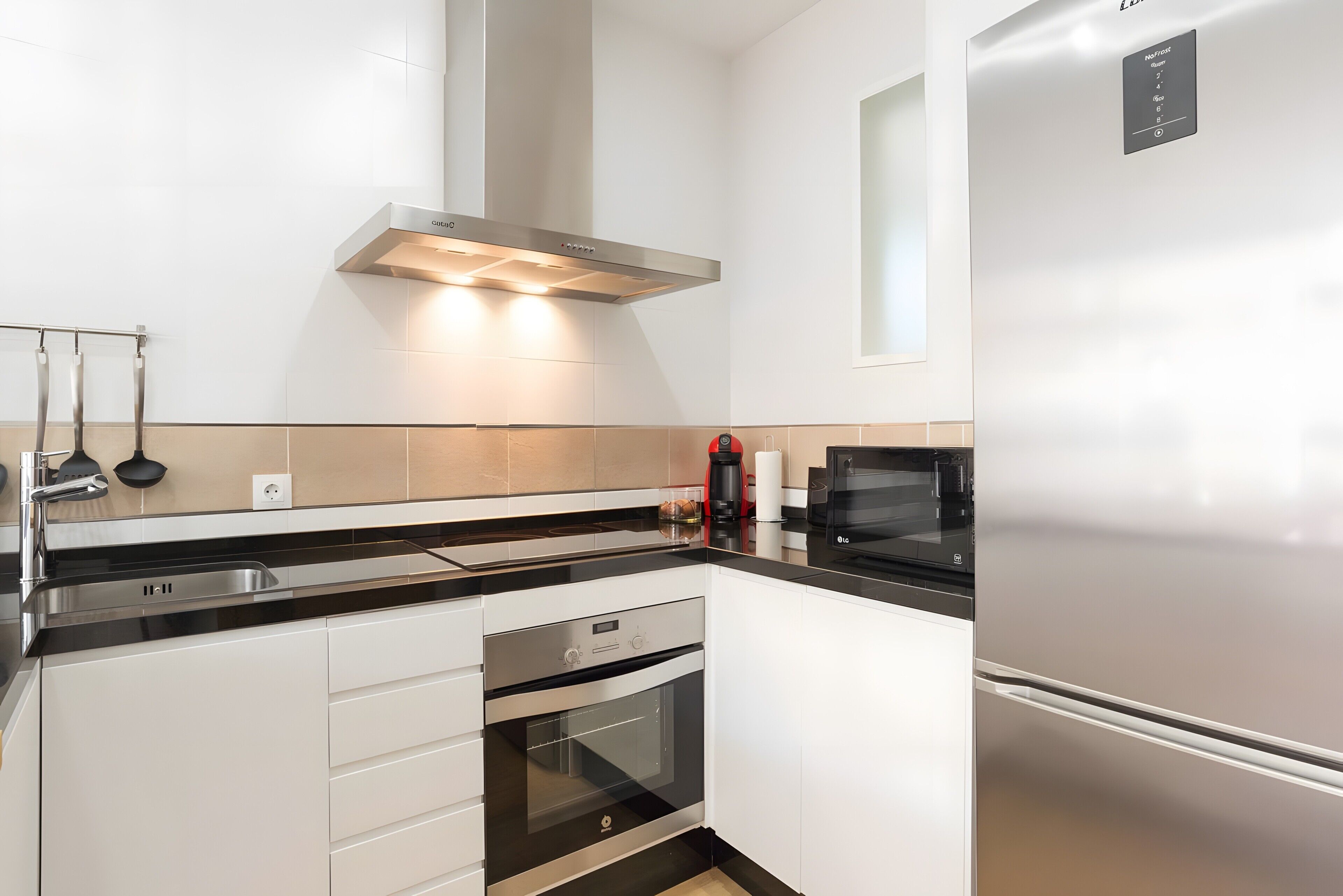 Eine moderne Küche mit Edelstahlgeräten, einem Backofen und einer Mikrowelle.