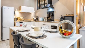 Una cocina moderna con zona de comedor, horno empotrado y un ventanal grande.