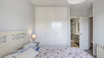 Et soveværelse med en seng, et sengebord, en lampe og et klædeskab.