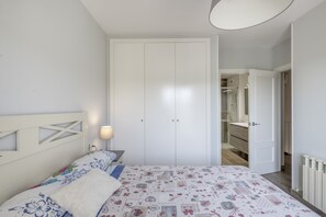 Una camera da letto con un letto, un comodino, una lampada e un armadio.