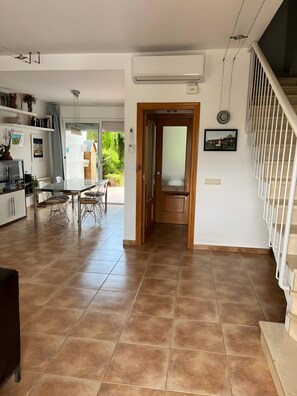 Una cocina amplia con comedor, una escalera y vistas al exterior.