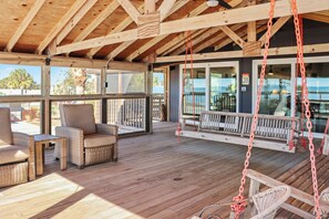 A wooden deck with wicker furniture, a swing, and a view of the ocean. - 🌊Beach View-Easy Walk to Beach-4BR Home-Screened Deck-Quarters B🌊 (Mexico Beach)