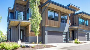 A modern multi-story building with large windows and a wooden facade. - Modern Home in Canyons Village by InvitedHome | Hot Tub, Game Room, Hike, Bike (Park City)