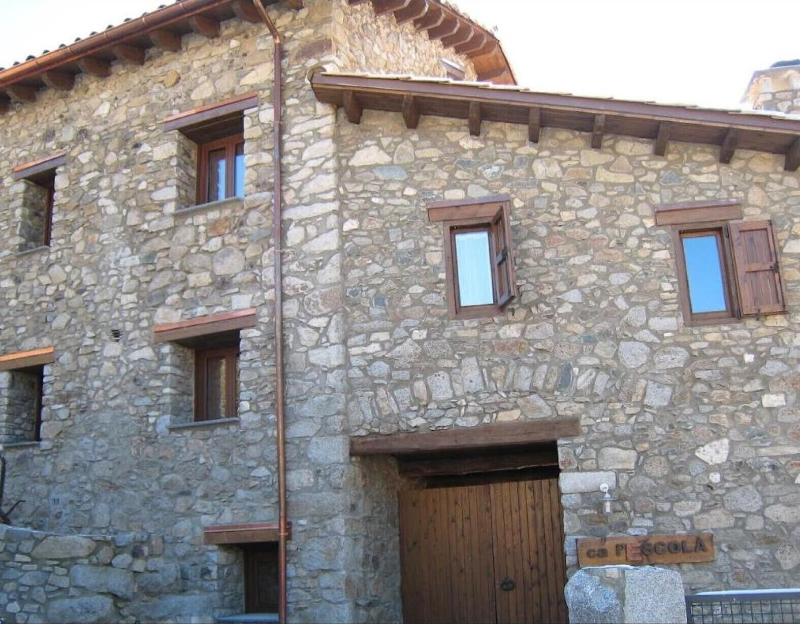 Un edificio de piedra con varias ventanas y una puerta de madera.
