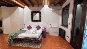 Um quarto com cama, espelho, cômoda e radiador.