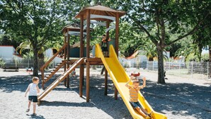 A playground with a wooden play structure, including a slide and climbing elements.