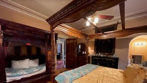 A traditional four-poster bed with a canopy, a separate bed with a patterned bedspread, and a large mirror above the bed. - Upjohn House Inn (Kalamazoo)