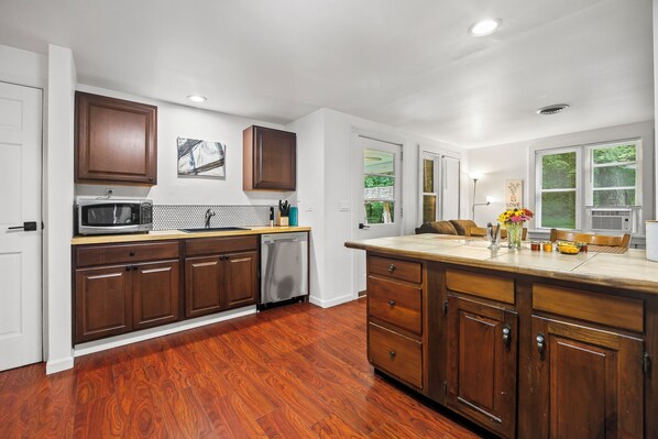 A modern kitchen with wooden cabinets, a microwave, and a dishwasher.
