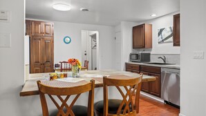 A modern kitchen with wooden cabinets, a microwave, and a dishwasher. - The Chicken Coop (Staatsburg)