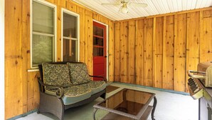 A wooden exterior with a glass table and a wicker sofa. - The Chicken Coop (Staatsburg)