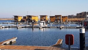 Ein Yachthafen mit angedockten Booten und einer Reihe gelber Gebäude.