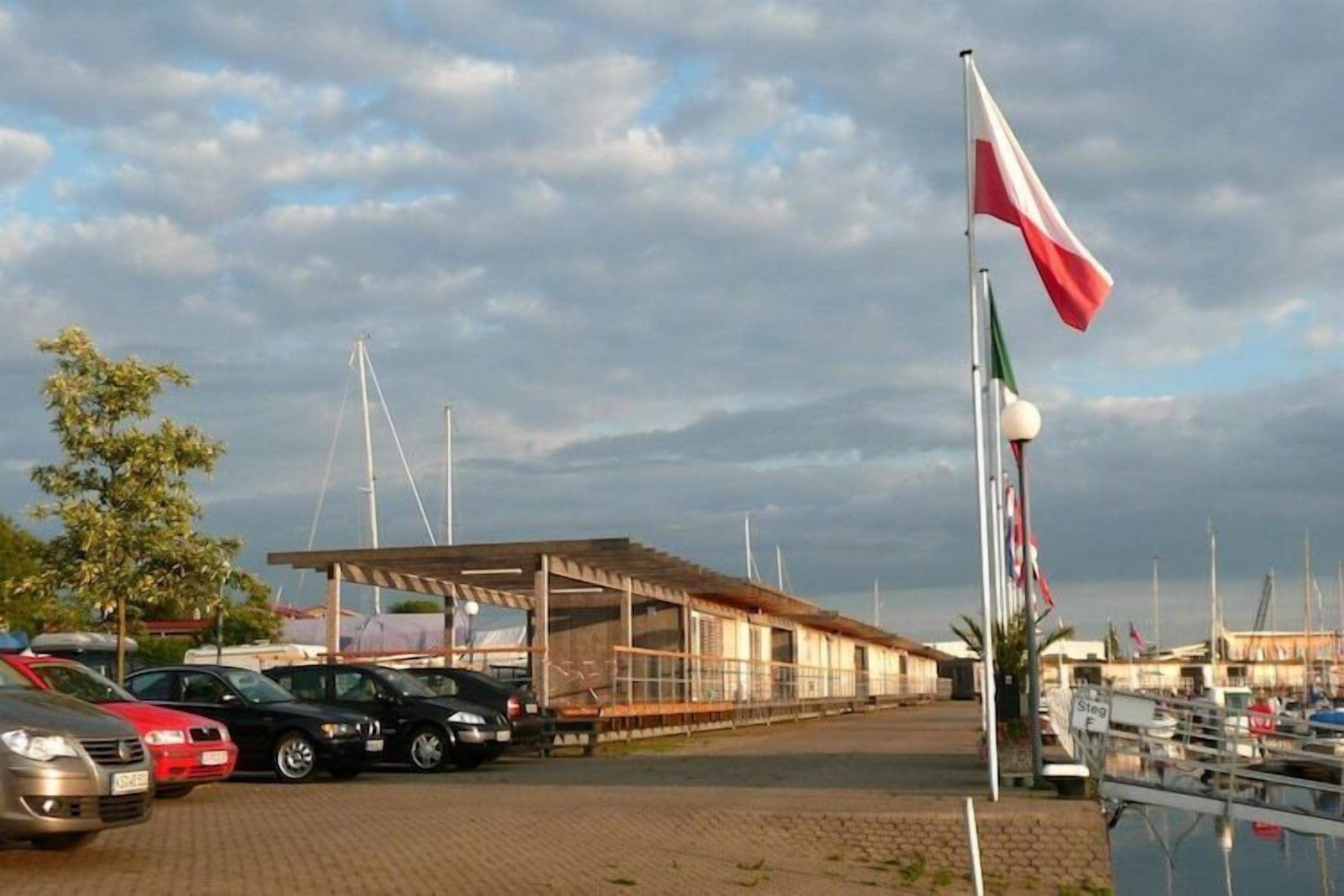 A marina with parked cars and a covered building.