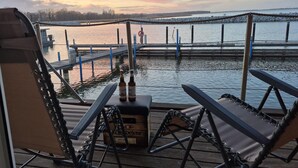 A dock with chairs and a cooler, a wooden pier, and a calm body of water. - Hausboot in Barth am Barther Bodden (Barth)