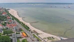 An aerial view of a coastal town with a sandy beach, a marina with boats, and buildings along the shore. - Hausboot in Laboe an der Kieler Foerde (Laboe)