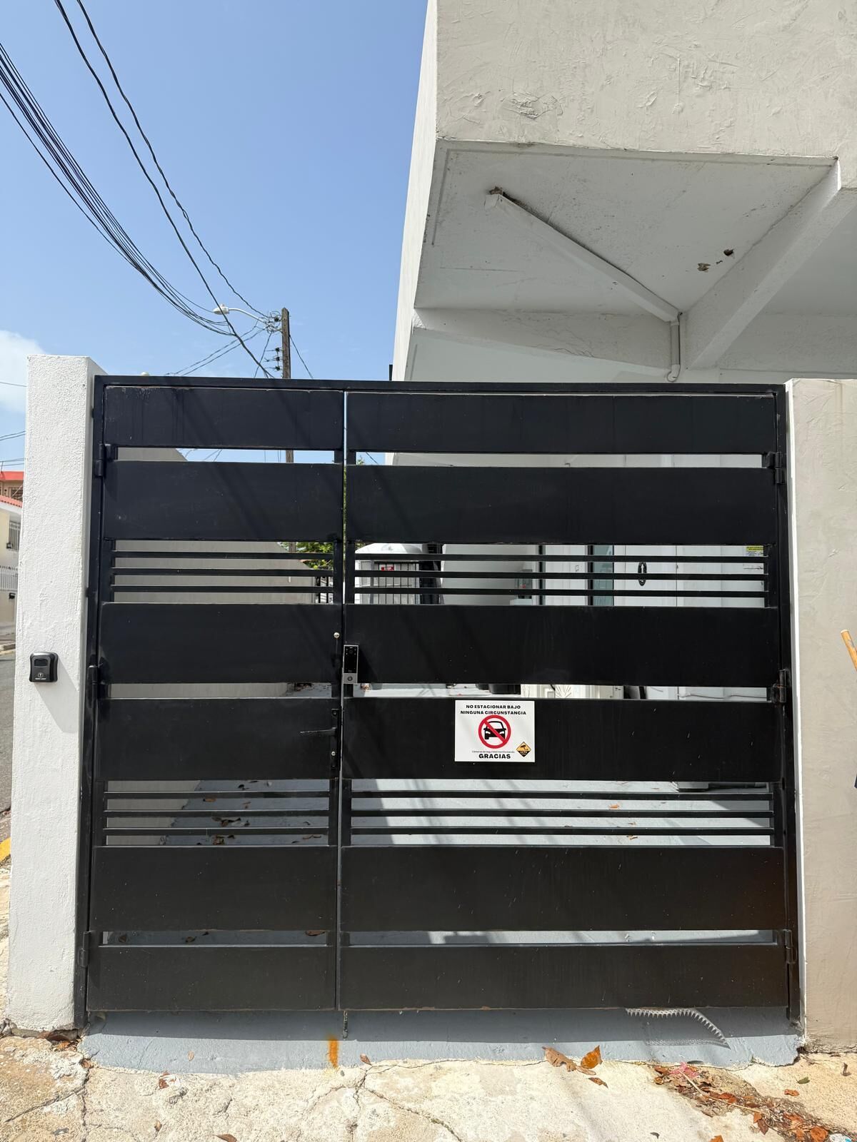 Una reja de metal negro con un letrero que prohíbe estacionar.