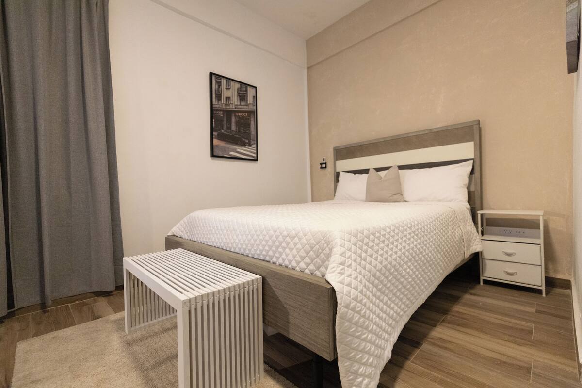 Une chambre à coucher avec un lit, une table de chevet et une commode.