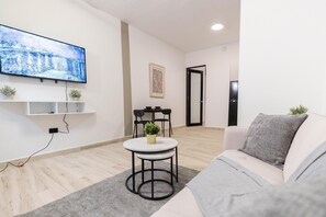 شقة مريحة - منظر للمدينة | منطقة المعيشة | تلفزيون ذكي بحجم 40-بوصة يعرض قنوات تلفزيونية رقمية