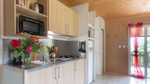 Eine moderne Küche mit Holzausstattung, einer eingebauten Mikrowelle und einem Gasherd.