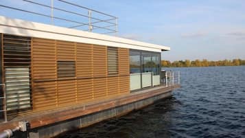 Een moderne rijkszacht met houten gevel, grote ramen en een dek.