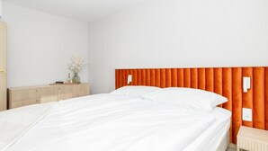 A bedroom with a bed, a bedside table, and a nightstand.