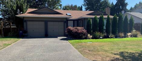 A two-story house with a garage, a driveway, and a well-maintained lawn.