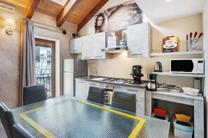 Une cuisine moderne avec une table en verre, des appareils électroménagers en acier inoxydable et une vue sur l’extérieur.