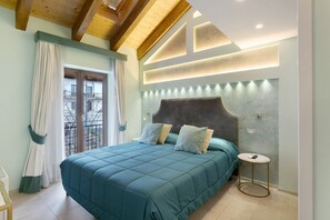 Une chambre à coucher avec un lit, une table de chevet, une fenêtre avec des rideaux et un balcon.