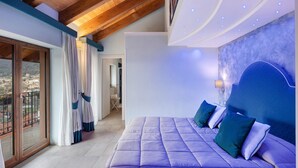 Ein Schlafzimmer mit einem großen Bett, Blick auf die Stadt und einem Balkon.
