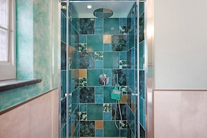 Una ducha con puerta de cristal y ducha de mano.