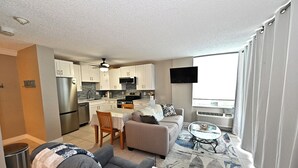 A modern apartment with a kitchen, dining area, and living room.