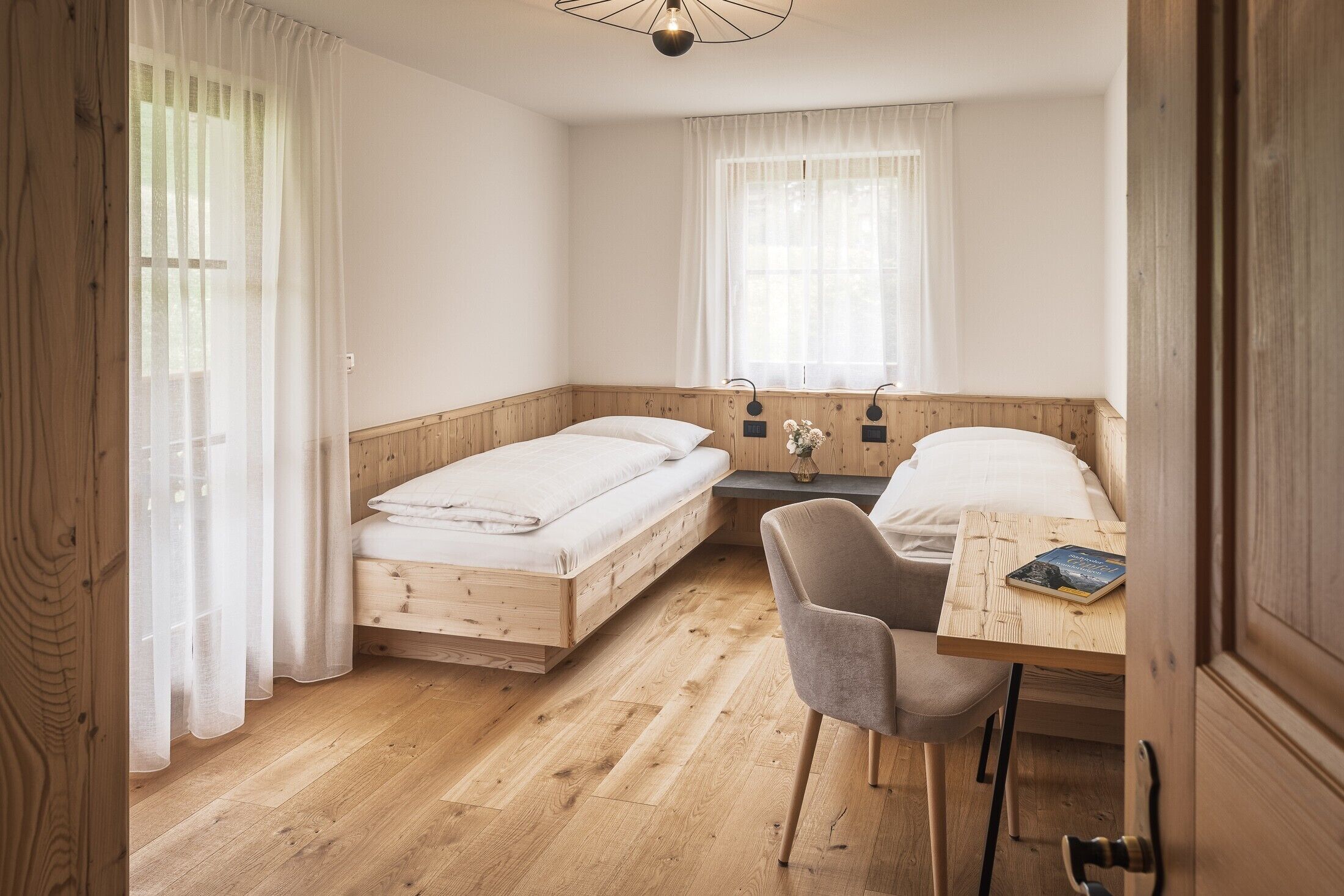 Une petite pièce agréable, avec un lit en bois, un bureau et une chaise.