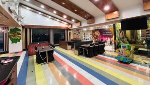 A hotel lobby with a colorful striped floor, wooden ceiling beams, and a reception area with a poster advertising bridal services. - HOTEL INDRALOK INN (Hazaribagh)