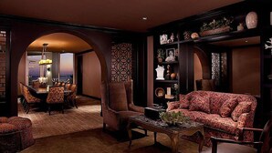 A luxurious living room with a sofa, armchairs, a coffee table, and a dining area with a chandelier. - The Cozy Corner | Dual Beach & Pool Views (Galveston)