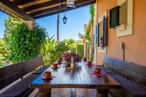 An outdoor wooden table with chairs, a metal pitcher, and pink flowers. - Villa 'Mil Flores, Purer Luxus' with Mountain View, Wi-Fi and Air Conditioning (Inca)