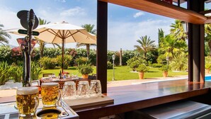 Une table avec des chopes et des verres à bière, un robinet à bière et un parasol de patio.