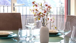 Une table à manger avec des assiettes, des verres et un vase rempli de fleurs.