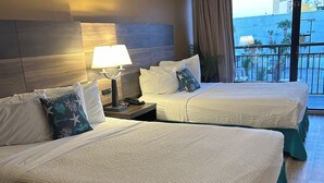 A hotel room with two beds, a nightstand with a lamp, and a view of the city through large windows. - Stylish ocean view 2 queen efficiency condo in marvelous Myrtle Beach (Myrtle Beach)