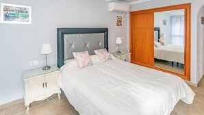 A bedroom with a bed, a nightstand, a mirror, and a wardrobe. - Cruz del Monte in Cómpeta (Cómpeta)