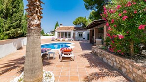A pool area with lounge chairs and a stone wall. - Cruz del Monte in Cómpeta (Cómpeta)
