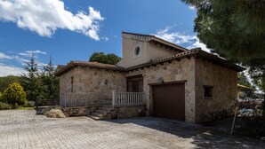 Un edificio de piedra con techo de tejas, un pequeño porche y un garaje.